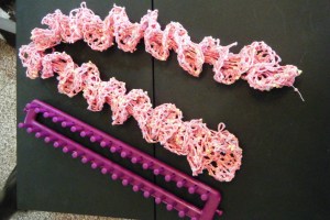First step:  make hairpin lace ribbon.  Second step, knit using loops for stitches.  (knit 6 turn repeat until out of ribbon or proper length)